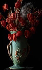 Still life: Vintage Roseville Bittersweet vase with dried Chinese Lantern seed pods and a squirell tail.