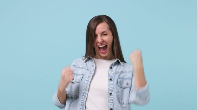 Happy young woman 30s years old in denim jacket white t-shirt look camera countdown 1 2 3 one two three go celebrate win rejoices doing winner hands gesture isolated on pastel blue background studio