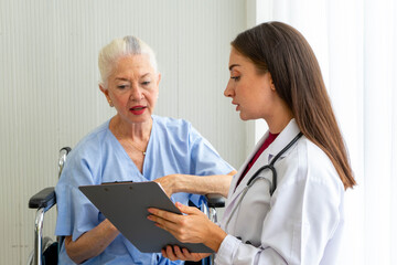 Caucasian old senior depressed upset woman patient on wheelchair talking to medical doctor with stethoscope  in hospital 