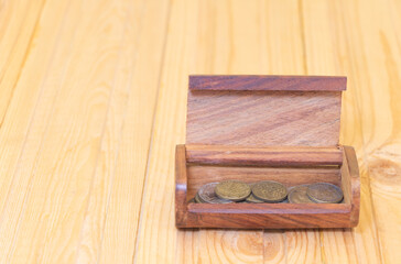 Wooden treasure chest with a few coins on wooden background. Concept of making money - business and so on