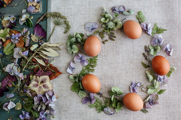 Obraz na płótnie Canvas Easter wreath of dried flowers and eggs on fabric