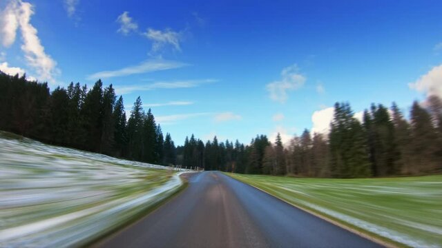Hyperlapse accelerated POV drive across beautiful countryside scenery, forest trees, narrow asphalt road, car travel gopro point of view, blue sky