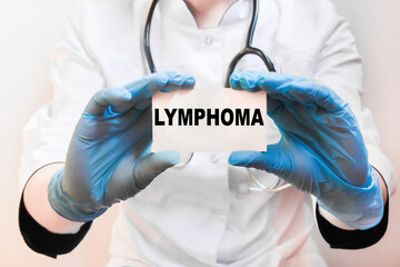 The doctor's blue - gloved hands show the word LYMPHOMA - . a gloved hand on a white background. Medical concept. the medicine