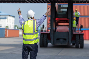 The foreman forces a hand signal to order the claim car to work in the container yard.