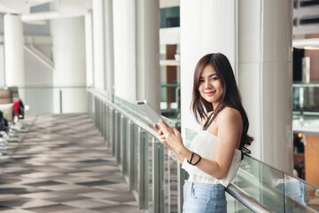 Working asian women white shirt blue jean clothe black long hair stand using tablet. Businesswoman working with tablet to connect network wifi. internet of things technology people concept.