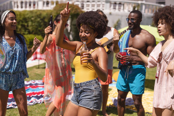Diverse group of friends having fun and dancing at a pool party