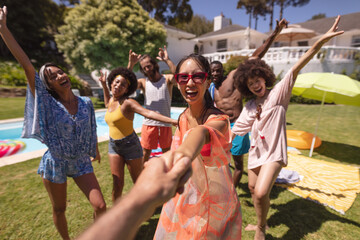 Fototapeta premium Diverse group of happy friends having fun dancing at a pool party