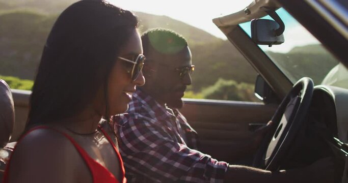 African american couple using map while sitting in convertible car