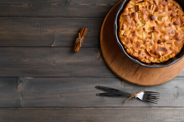 Apple pie in a round shape on a wooden background. Apple charlotte
