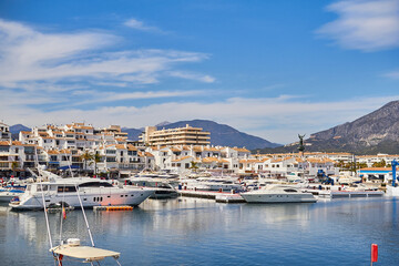 Fototapeta na wymiar View of Puerto Banus marina with boats and white houses in Marbella town at sunrise, Andalusia, Spain