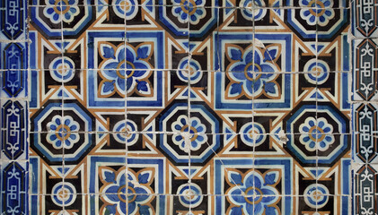 Details of ancient tiles with geometrical shapes, covering facades of buildings in Lisbon. Typical sample of traditional Portuguese craft.