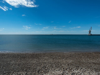 Playa solitaria con conchillas, agua clara y cielo nublado