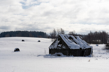 deep snow, where you can see some trees and an old abandoned wooden building
