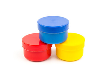 Plastic jars with paint of different colors for children's creativity on white background. Paint bottles for art