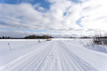  road in the middle of the field that is covered with snow