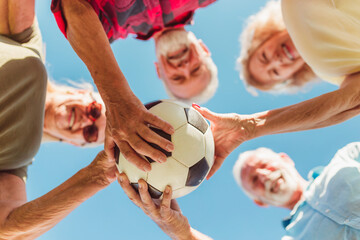 Fototapeta premium Senior people holding a soccer ball