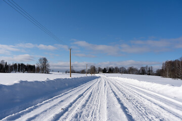 Obraz premium road in the middle of the field that is covered with snow