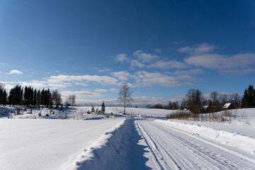 Fototapeta na wymiar road in the middle of the field that is covered with snow