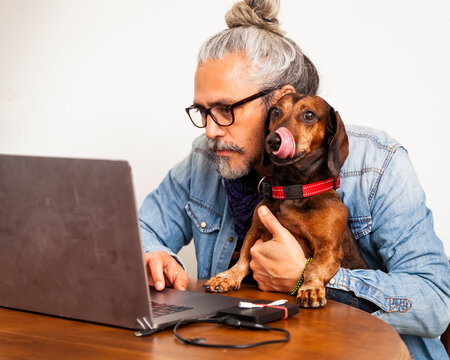 Man at home office with cute dachshund dog sitting close together