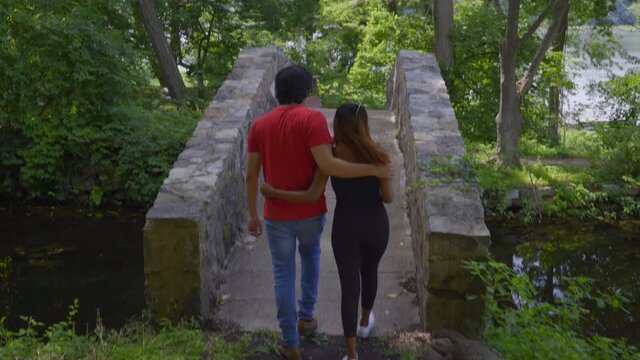 Young Couple Walks to Stone Bridge and Stops to Take a Picture of Park in Roslyn