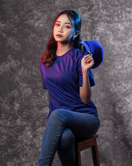 Model wear plain hat while stylish. Fashionable blank t-shirt and design mockup. Beautiful make-up model wear baseball cap with a long hairstyle posing in the studio background. Smiling sporty girl.