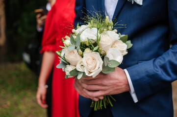 Bouquet of flowers in the groom's hand