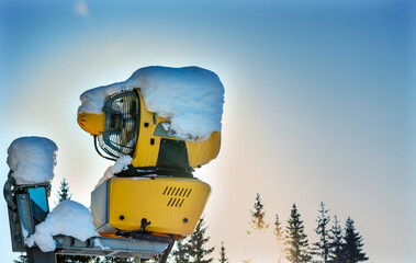 Snow making machine at a ski resort on a sunny winters day.