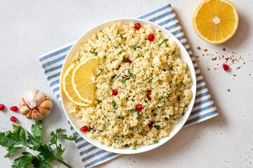 Cooked couscous in a ceramic plate on a white concrete background top view. Maghreb cuisine, vegan...