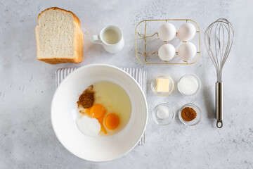 Flay lay of ingredients for making french toast (or wentelteefjes in Dutch) on white grey background. view from above