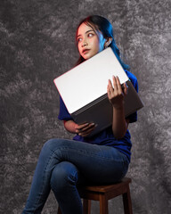 Beautiful young woman, charming business CEO holding notebook wearing blank t-shirt while stylish isolated background. Portrait of a happy and excited woman with a laptop. Models for new notebook.
