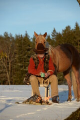 Lagerfeuerromantik. Cowboy mit Pferd am Lagerfeuer