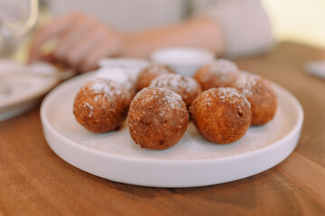 Appetizing and beautiful round fried donuts on a white plate
