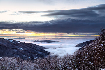 Foggy winter landscape before sunset in Ligurian Apennines mountains in Lombardy, Italy.