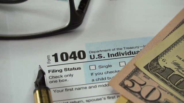 Blank Form 1040 U.S. Individual Income Tax Return with Pen and dollar banknotes. Tax Payment Concept. Filing Taxes Document