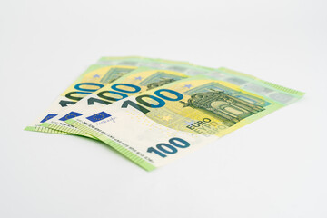 Green new one hundred Euro banknotes on a white studio background. 100 Euros lying on a white surface as the currency in Europe.