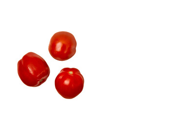 Drei kleine Kirschtomaten, die lose auf einem weißen Hintergrund liegen.