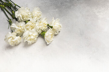 Bouquet of white carnations on a gray background
