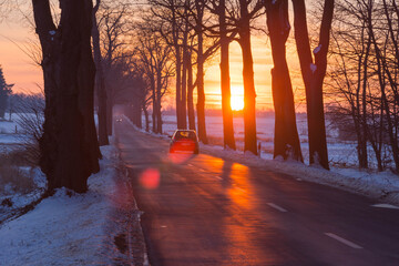 Zachód słońca nad asfaltową drogą.