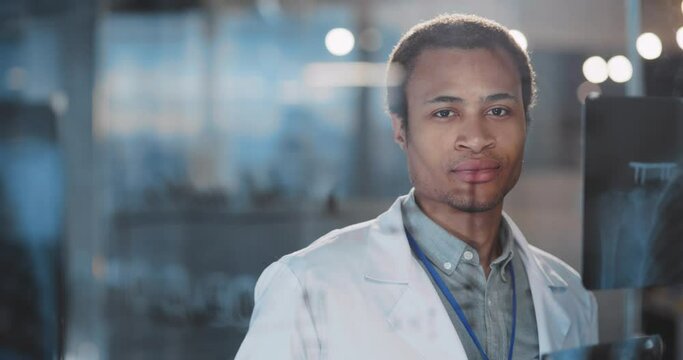 Portrait of handsome positive african american doctor physician nurse intern assistant studying in modern hospital cooperating at office.