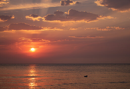red and orange sky during sunrise over the beach. colorful sky during sunrise. reflection of the sun on the lakefront.