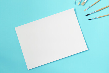 blank a4 paper sheet with paint brushes, mockup for arts