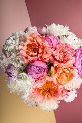 Abundance of Fresh bunch of Peonies Bouquet of different pink colors on light background. Card Concept, copy space for text