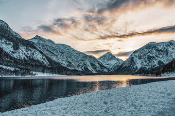 View from the Uferstrasse to the Plansee in Tyrol, Austria. .Romantic sunset behind the mountains.