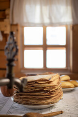 Fototapeta na wymiar Pancakes in a wooden house on the background of a window.