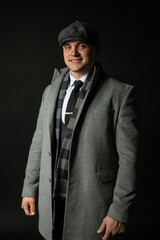 in a coat and a cap Young male three piece suit male adult man, attractive background. shirt elegance background black bodybuilder