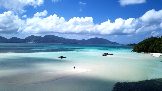 aerial view from Saint-Anne Marine National Park over white sandbars, blue sea to Mahe Island