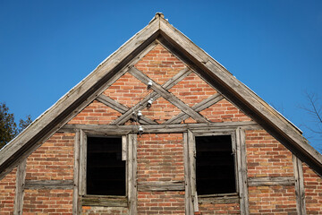 Old abandoned window, detail of a window of a house in ruins, evictions and abandonment, crisis, wooden and brick house before total destruction	