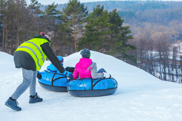 people riding snow tubing at winter park