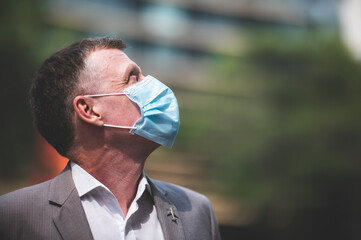 professional adult businessman wearing surgical face mask to protect of coronavirus covid-19,...