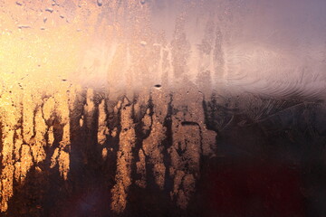 Frozen drops of condensation on a transparent glass window in the winter season with natural sunlight through the glass, high humidity, temperature difference, natural background